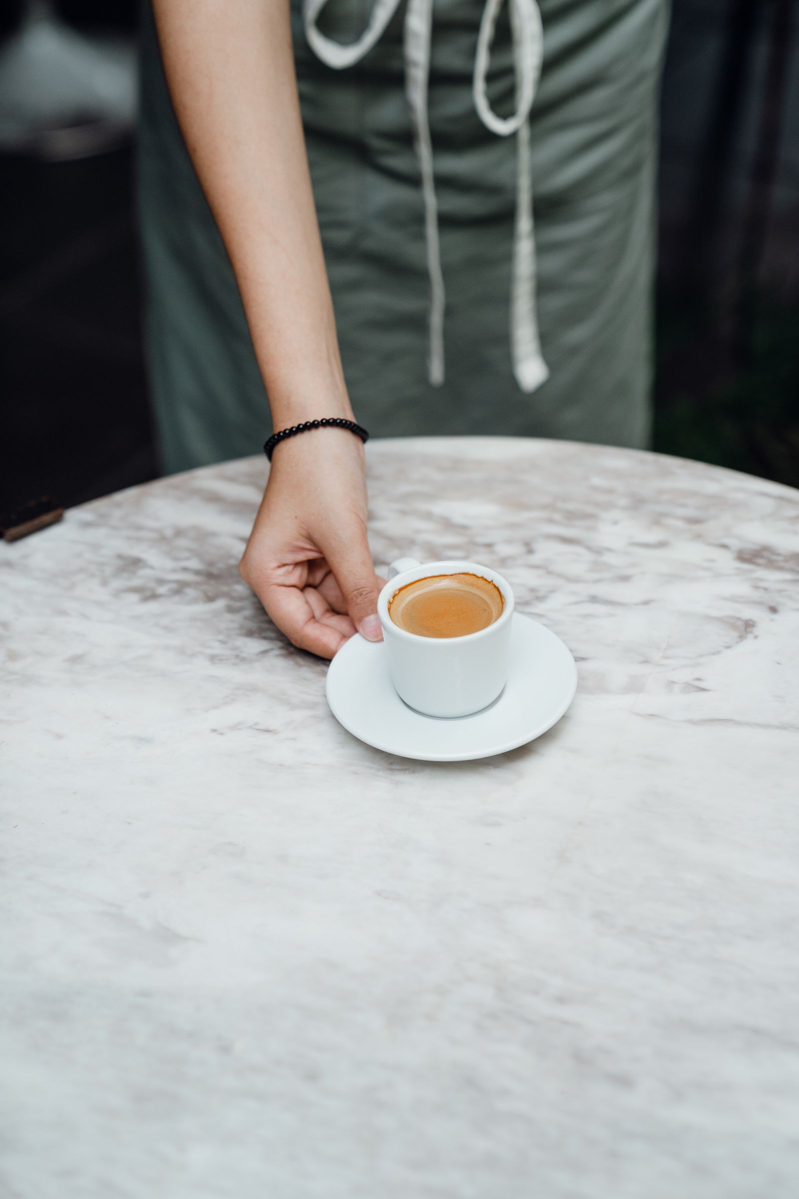 Barista σερβίρει espresso σε μαρμάρινο τραπέζι